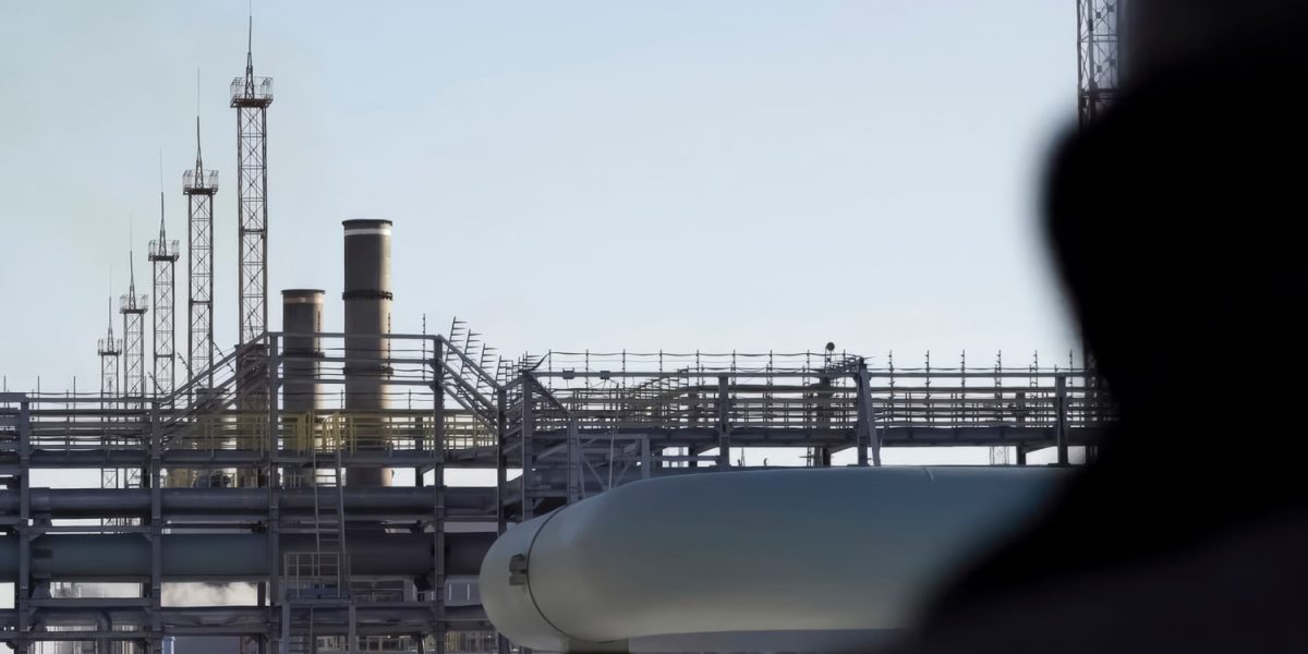 Oil worker view from back, looking at gas oil equipment station