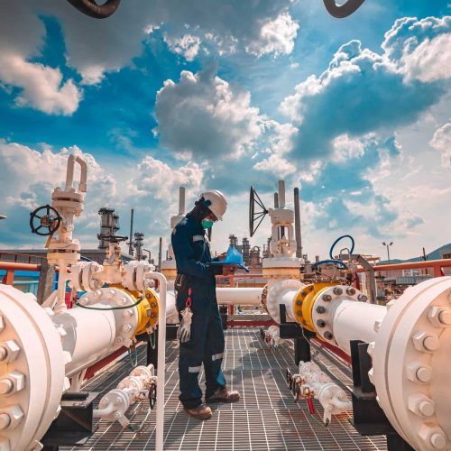 Male worker inspection at steel long pipes and pipe elbow in station oil factory during refinery valve of visual check record pipeline tank oil and gas industry
